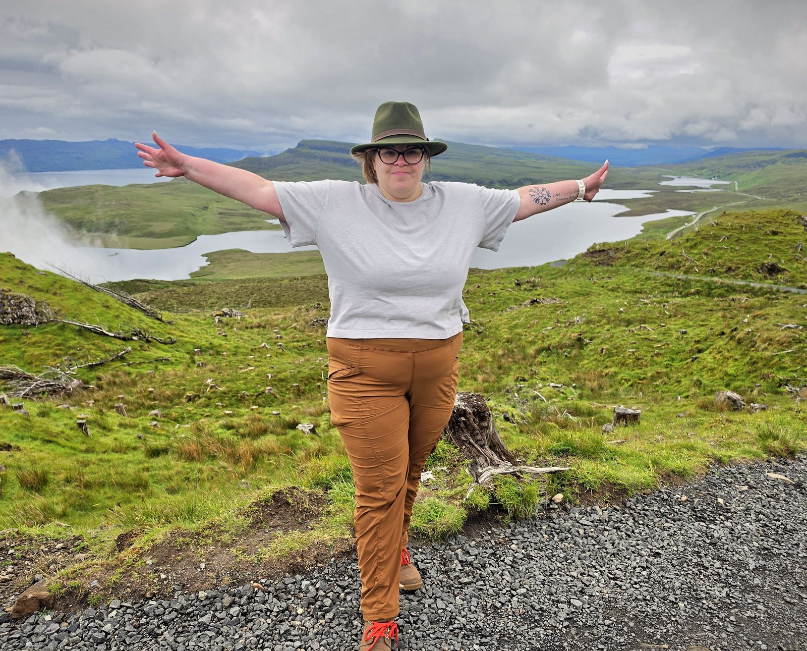 Ashley with arms outstretched above a Highland loch